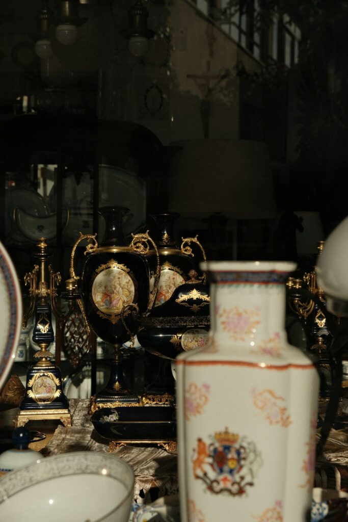 Person documenting jewelry, artwork, and collectibles beside receipts and insurance papers on a home table.